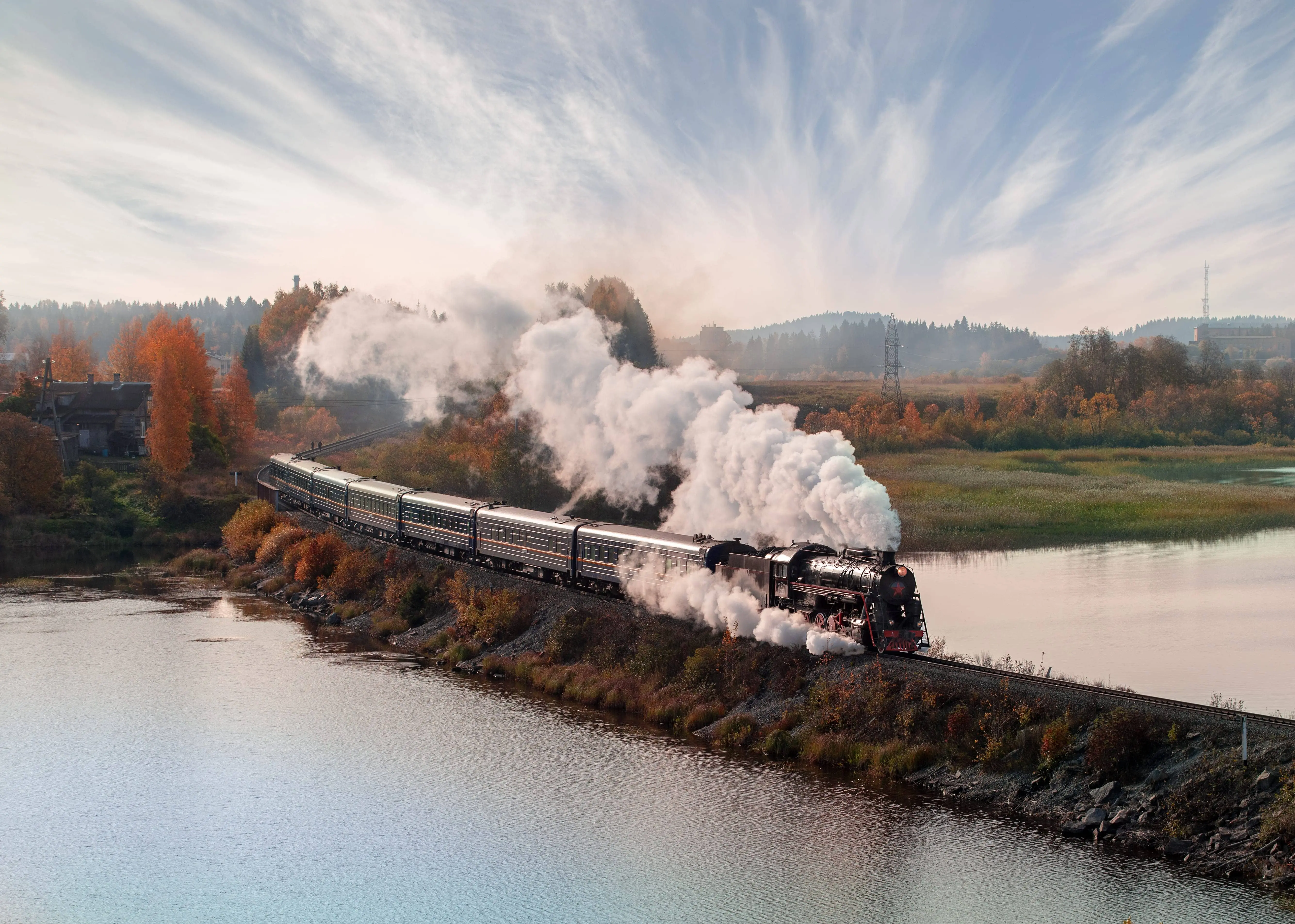 Steam Train: A steam locomotive travelling amidst autumn leaves