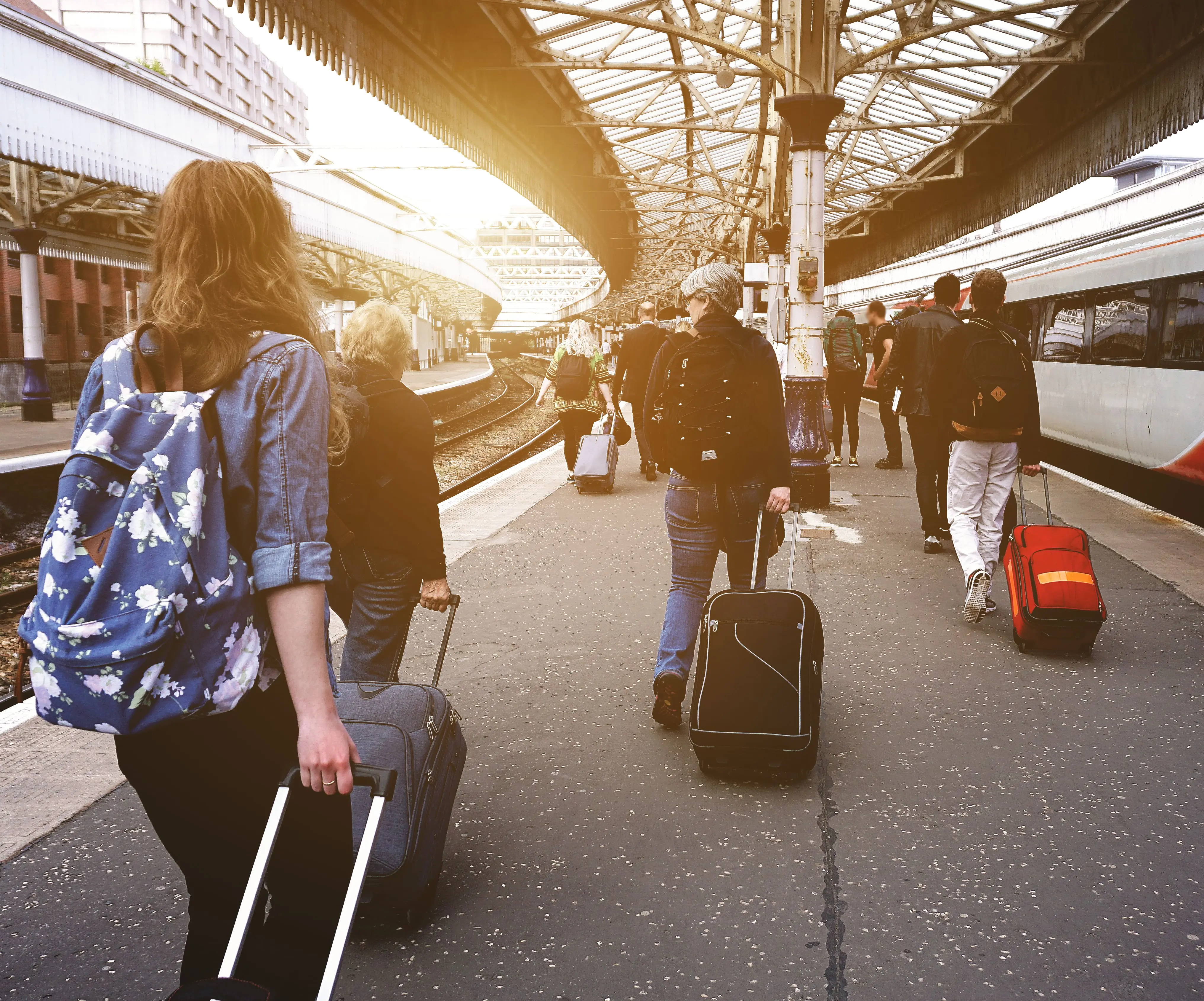 Passengers walk along a train platform