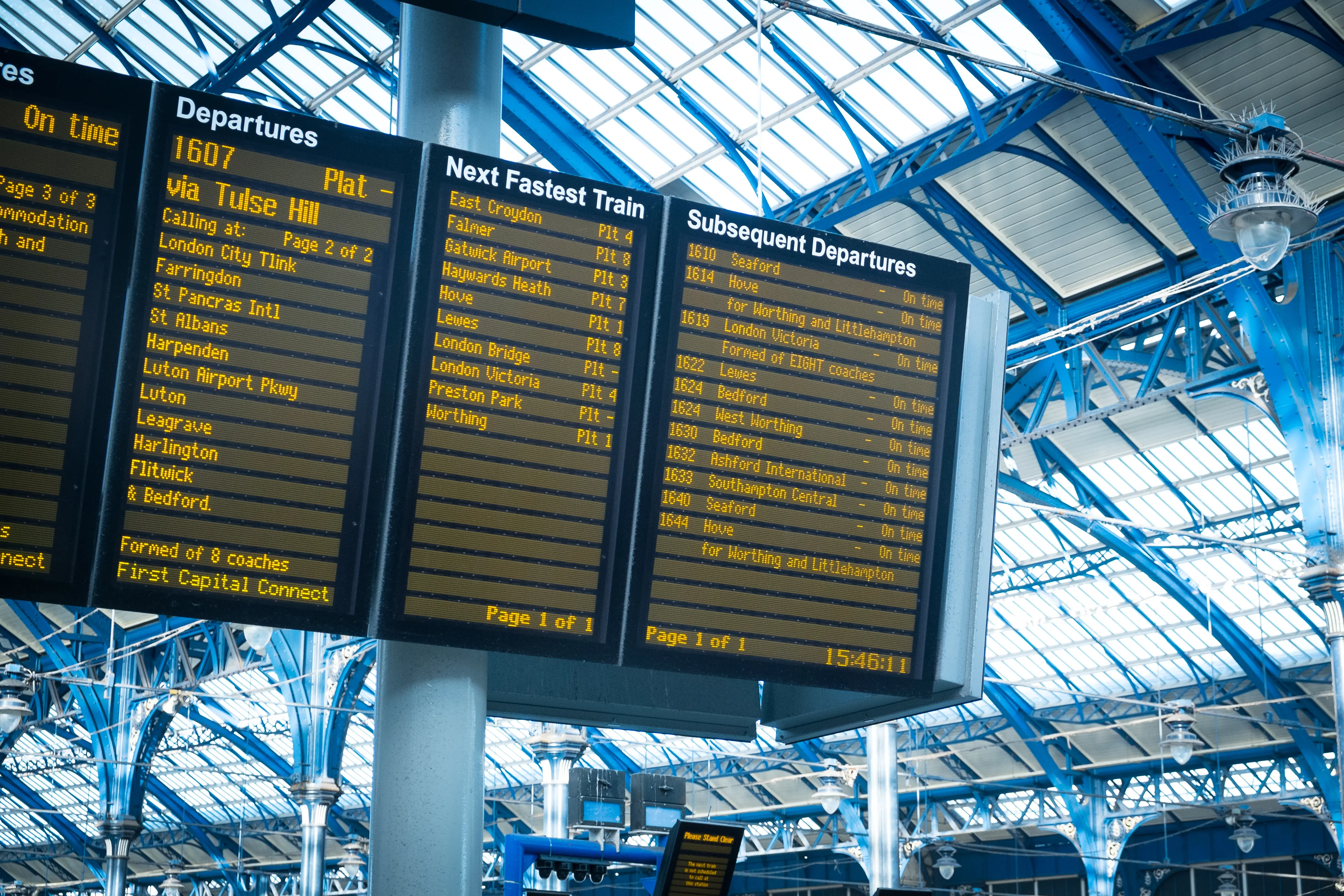 Train Timetables: A mid-shot of a train timetable at a station, showing a series of destinations, including Stafford and Gatwick Airport.