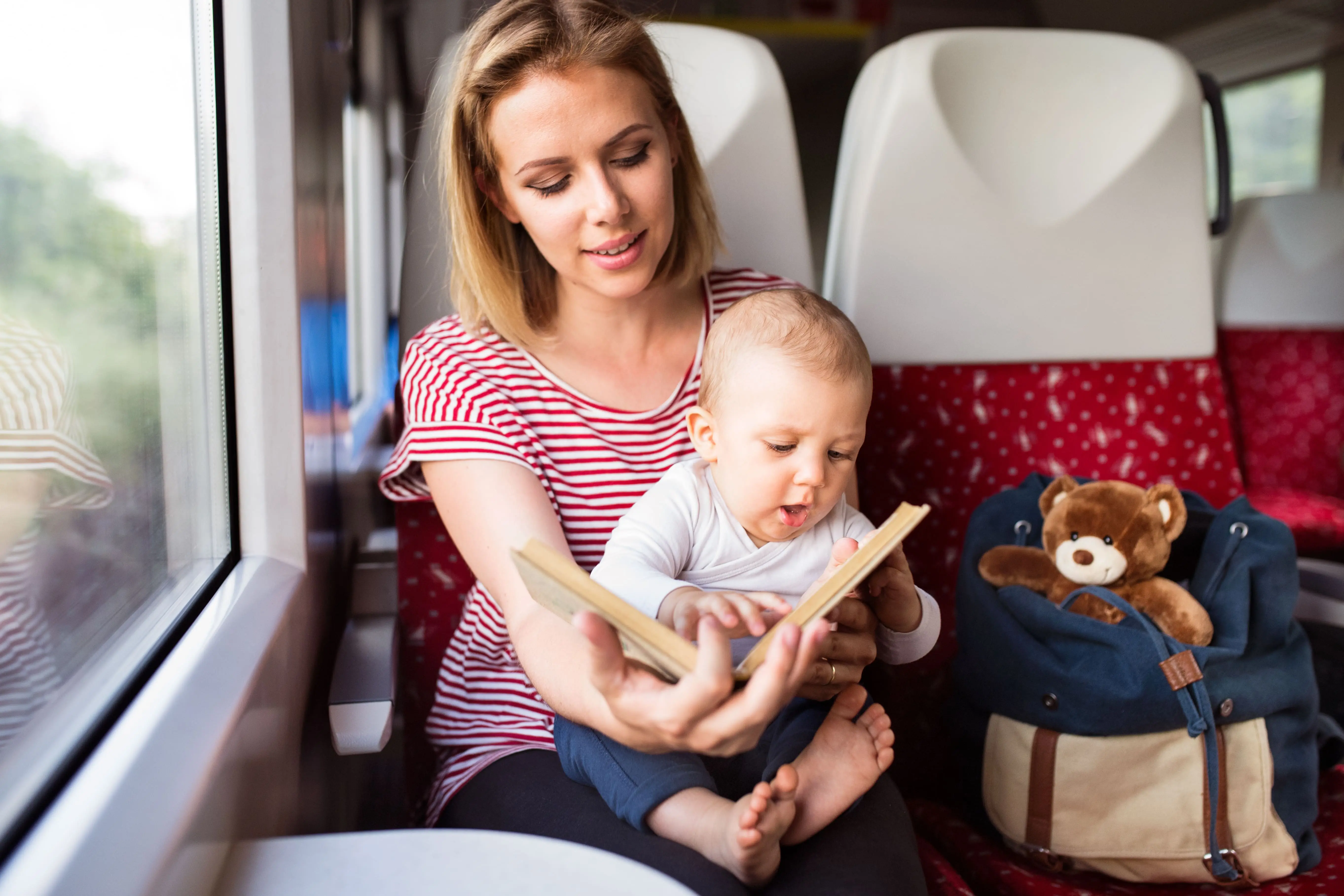 Train Literature: A young mother reads a book to her young son onboard a train.