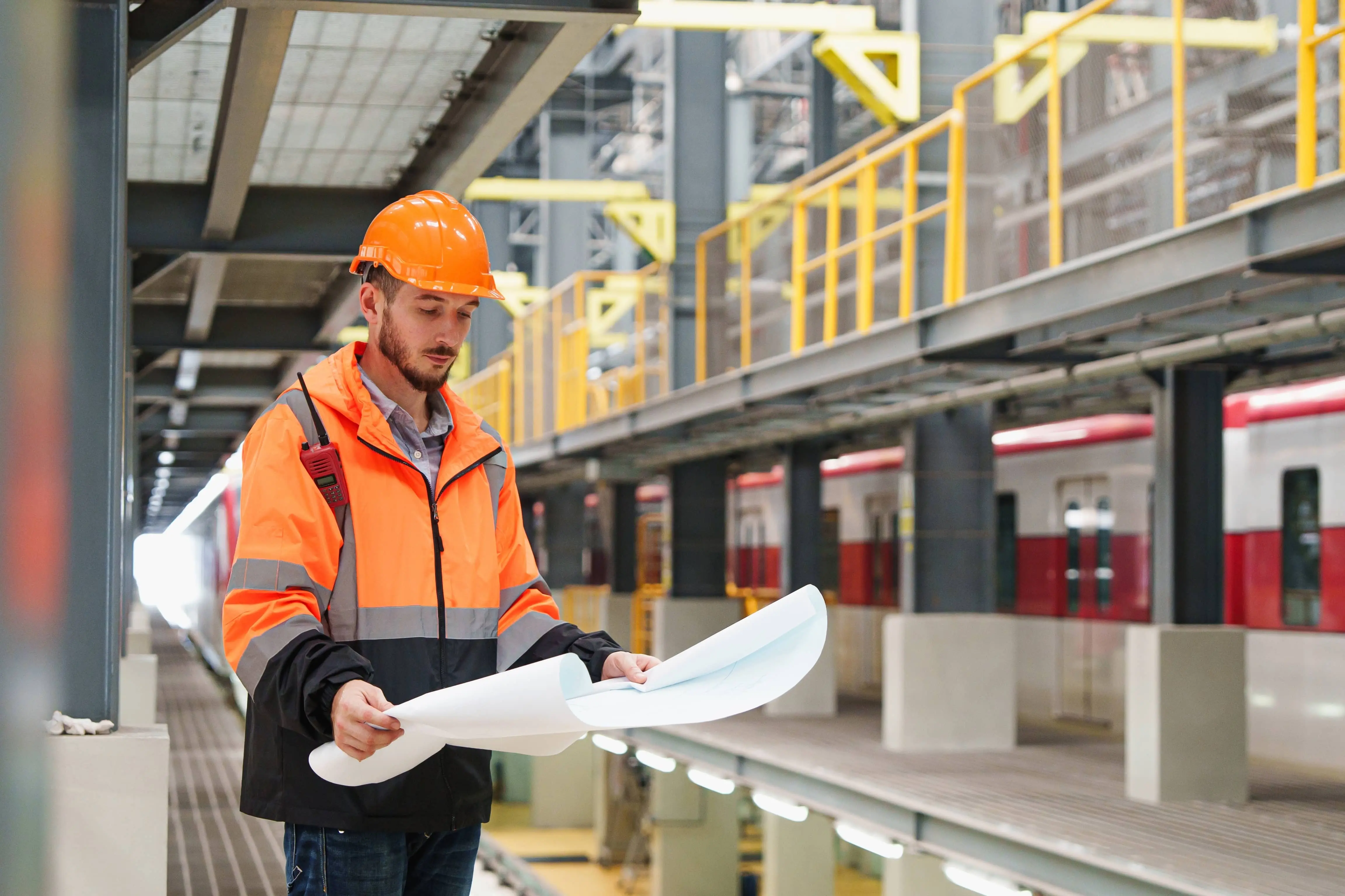 A railway engineer holding blueprints for project.